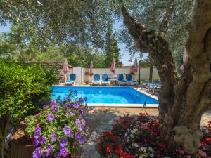a pool with chairs and flowers in a yard at Apartment Nena - PRC426 by Interhome in Nova Vas