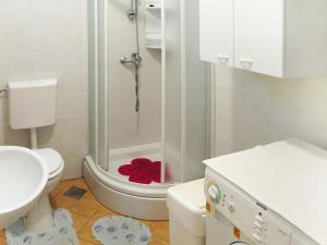 La salle de bains est pourvue de toilettes, d'une douche et d'un oreiller rouge. dans l'établissement Apartment Vivoda - PUL168 by Interhome, à Štinjan