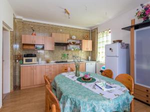 Il comprend une cuisine équipée d'une table et d'un réfrigérateur blanc. dans l'établissement Apartment Bellevue - PUL331 by Interhome, à Pješčana Uvala