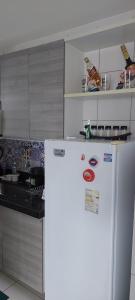 La cuisine est équipée d'un réfrigérateur blanc. dans l'établissement Residencial Amazonia Apto 1205, à João Pessoa