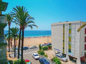 ベニドルムにあるApartment Turia Playa by Interhomeのヤシの木と建物のあるビーチの景色を望めます。