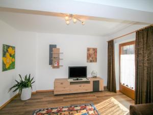 a living room with a television on a wooden cabinet at Apartment Hundsbichler-2 by Interhome in Hippach