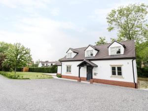 a white house with a driveway at Appletree Cottage in Bishampton