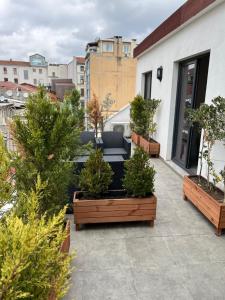 a patio with potted trees and a couch on a building at Liberi Hotel Taksim in Istanbul