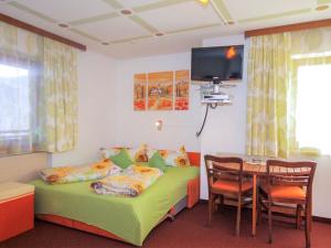 a room with a bed and a table with a tv at Apartment Karwendel by Interhome in Oberau