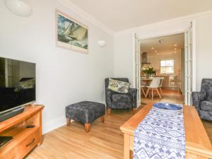 a living room with a tv and two chairs and a table at 7 The Retreat in Paignton