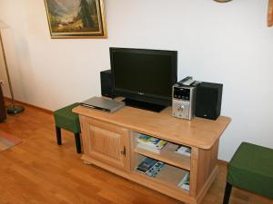 a living room with a tv and a table with a television at Apartment Bibelöd-2 by Interhome in Ruhpolding