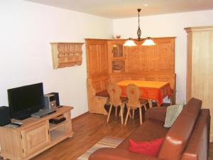 uma sala de estar com um sofá e uma mesa com uma televisão em Apartment Bibelöd-2 by Interhome em Ruhpolding