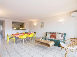 a living room with a couch and a table and chairs at Apartment Le Magellan-2 by Interhome in Saint-Raphaël