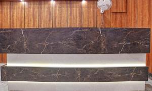a marble counter top in a room with wooden walls at Treebo Trend Shivaay in Indore