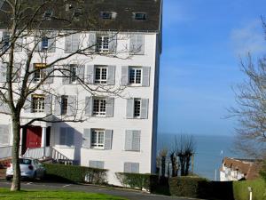 a white building with the ocean in the background at Apartment Le Parc Cordier-3 by Interhome in Trouville-sur-Mer