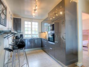 a kitchen with stainless steel appliances and a glass wall at Apartment Le Parc Cordier-3 by Interhome in Trouville-sur-Mer