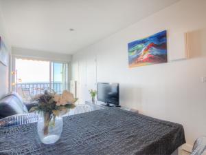 a room with a table with a vase with flowers on it at Apartment Le Parc Cordier-3 by Interhome in Trouville-sur-Mer +12 photos