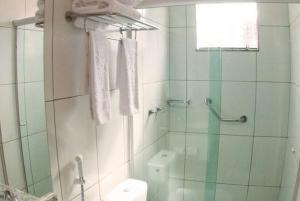 uma casa de banho com uma cabina de duche em vidro e um WC. em Hotel Golden Dolphin com café da manhã! Piscinas 24h em Caldas Novas