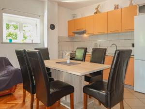 eine Küche mit einem Holztisch und schwarzen Stühlen in der Unterkunft Apartment Mila-2 by Interhome in Jadranovo + 37 Fotos