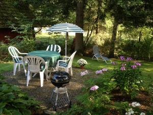 a table and chairs with an umbrella and a grill at Apartment Altes Forsthaus Sösetal by Interhome in Riefensbeek