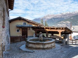 a fountain in front of a building with a house at Holiday Home Jouvenceaux by Interhome in Sauze dʼOulx