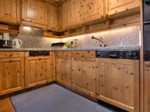 a kitchen with wooden cabinets and a sink at Apartment Chesa Polaschin B - B6 - Sils by Interhome in Sils Maria