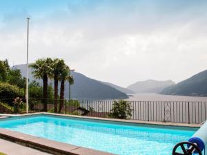 a swimming pool with a view of the water and mountains at Apartment Bissonella by Interhome in Bissone