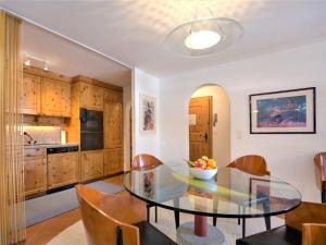 a kitchen and dining room with a glass table and chairs at Apartment Chesa Polaschin B - B6 - Sils by Interhome in Sils Maria