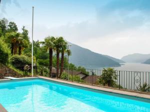 a swimming pool with a view of the water and mountains at Apartment Bissonella by Interhome in Bissone