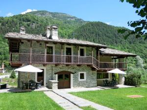 a large stone house with a balcony and a deck at Apartment Casa del Ponte - SMY612 by Interhome in Sampeyre