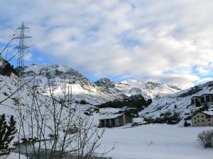 a snow covered mountain with a tower in the distance at Apartment Crap Milan by Interhome in Bivio