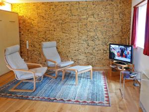 a living room with two chairs and a tv at Apartment Crap Milan by Interhome in Bivio