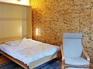 a small bedroom with a bed and a chair at Apartment Crap Milan by Interhome in Bivio +8 photos
