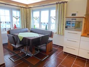 a kitchen with a table and chairs and windows at Holiday Home Edelmann by Interhome in Schnett