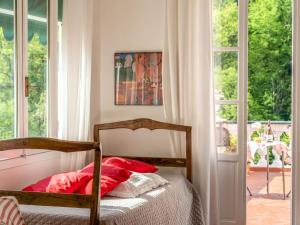 1 dormitorio con 1 cama con almohadas rojas junto a una ventana en Apartment Valeria - PRE131 by Interhome, en Praelo