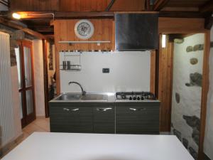 a kitchen with a sink and a stove at Holiday Home Caa de Sass by Interhome in Castelveccana +18 photos