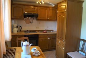 a small kitchen with wooden cabinets and a wooden table at Geißberghaus in Kaltennordheim