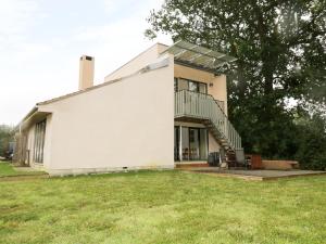 ein weißes Haus mit einem Balkon und einer Liegewiese in der Unterkunft Frater House in Alburgh