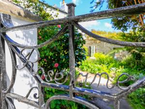 une ancienne porte en fer avec un jardin derrière elle dans l'établissement Rosevine, à Kingsbridge