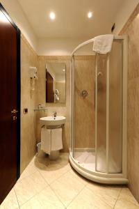 a bathroom with a shower and a toilet and a sink at Hotel City Legnano in Legnano