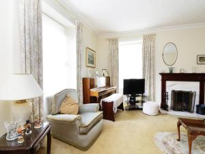 a living room with a couch chair and a television at Meadowside Farm in Coupar Angus