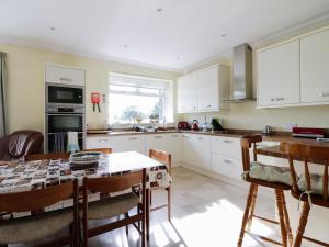 a kitchen with white cabinets and a table with chairs at Meadowside Farm in Coupar Angus