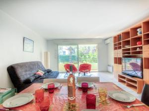 ein Wohnzimmer mit Tisch und Couch in der Unterkunft Apartment Le Magellan-1 by Interhome in Saint-Raphaël