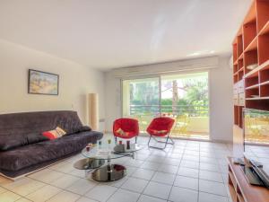 ein Wohnzimmer mit einem Sofa und zwei roten Stühlen in der Unterkunft Apartment Le Magellan-1 by Interhome in Saint-Raphaël + 12 Fotos