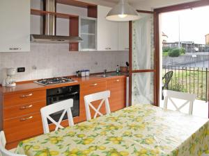 una cucina con tavolo e sedie e una cucina con finestra di Apartment Cielsereno - SLR246 by Interhome a Costarainera