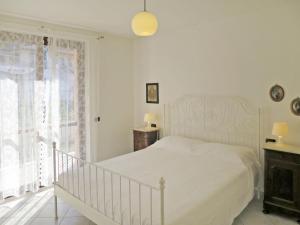 una camera bianca con un letto e una finestra di Apartment Cielsereno - SLR246 by Interhome a Costarainera