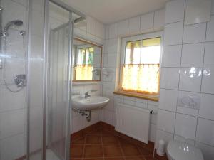La salle de bains blanche est pourvue d'un lavabo et d'une douche. dans l'établissement Apartment Hofresidenz-2 by Interhome, à Altenmarkt im Pongau