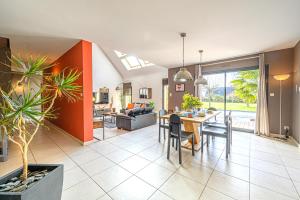 LE HAMEAU DE BIZOLE - Magnifique Maison contemporaine avec piscine chauffée في Saint-Nolff: غرفة طعام وغرفة معيشة مع طاولة وكراسي