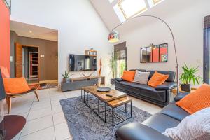 LE HAMEAU DE BIZOLE - Magnifique Maison contemporaine avec piscine chauffée في Saint-Nolff: غرفة معيشة بها أريكة وطاولة