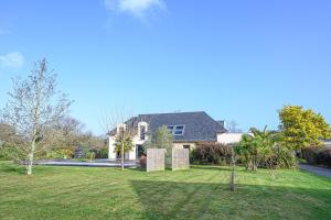 LE HAMEAU DE BIZOLE - Magnifique Maison contemporaine avec piscine chauffée في Saint-Nolff: منزل به ساحة بها عشب وأشجار