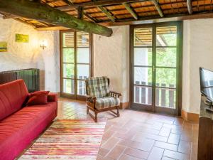 Reno Di LeggiunoにあるHoliday Home Casa del Pittore by Interhomeのリビングルーム(赤いソファ、椅子付)