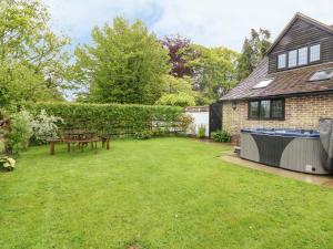 a backyard with a picnic table and a hot tub at Pump House in Horam