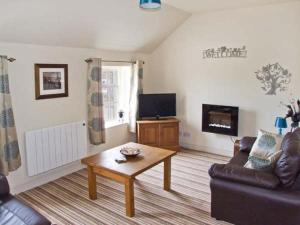 a living room with a couch and a coffee table at Curlew Cottage in Warslow