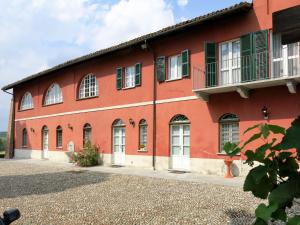 un edificio rosso con finestre bianche e persiane verdi di Holiday Home La Mondianese - AST310 by Interhome a Montemagno